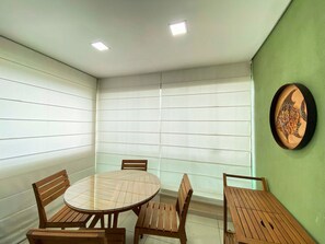 A room with a round table and four chairs, a green accent wall, and a framed fish artwork. - Carneiros Beach Resort by CTA (Tamandaré)