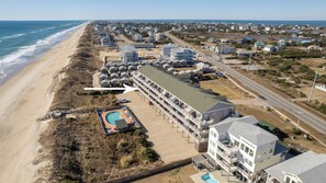 A coastal hotel with a pool, beachfront access, and multiple buildings. - Oceanfront Condo, Beach Access, Shared Pool, & Hot Tub (Hatteras)