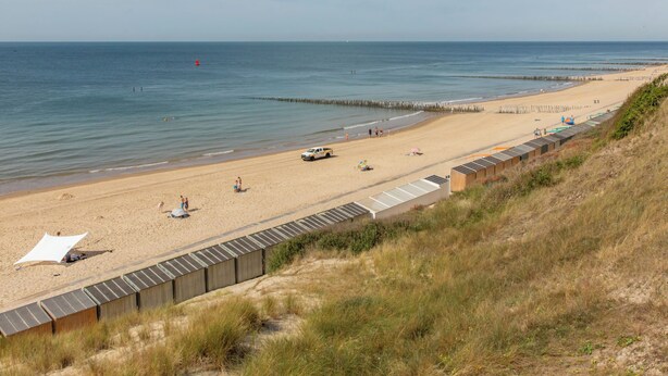 A beach with a wooden boardwalk, sandy beach, and a clear sky. - De Ruiser by Interhome (Biggekerke)