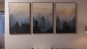 Three framed paintings of a forest scene on a wall. - Cozy South Addition Downtown Getaway - King Beds (Anchorage)