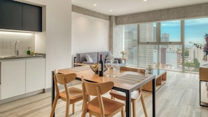 A modern kitchen with a dining area, large windows, and a city view. - Nido Nomad Pablo Neruda GDL (Guadalajara)