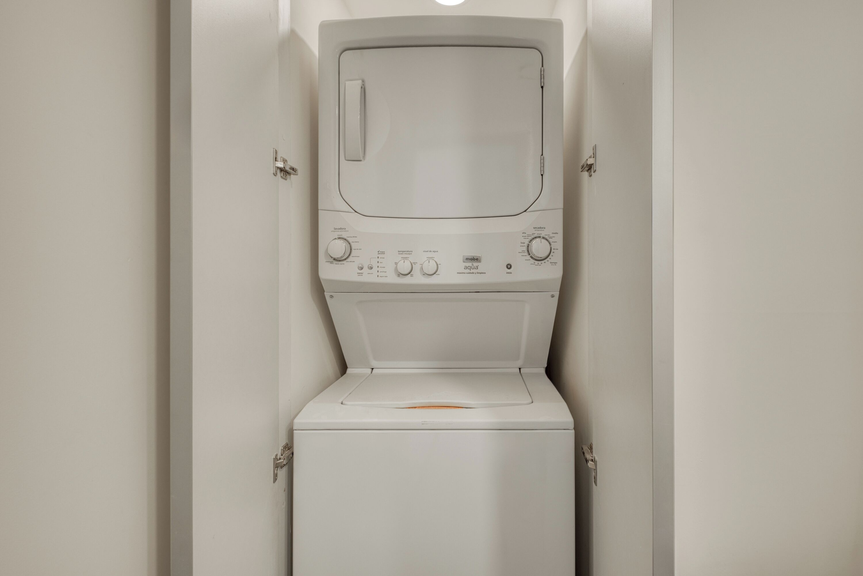 A white washing machine in a bathroom with a closed door.
