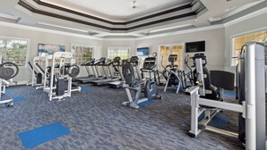 Ein Fitnessstudio mit verschiedenen Trainingsgeräten, darunter Laufbänder, Kraftgeräte und ein Ergometer.