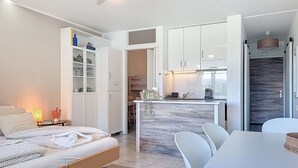 Un dormitorio moderno con cama, mesita de noche y otra mesilla.