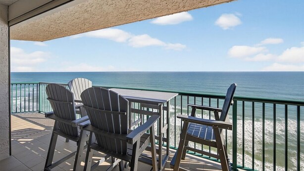 Un balcone con poltrone Adirondack e un tavolo vista oceano.