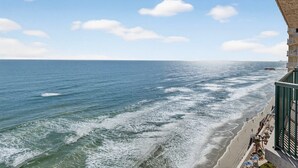 Paesaggio costiero con spiaggia e onde oceaniche.