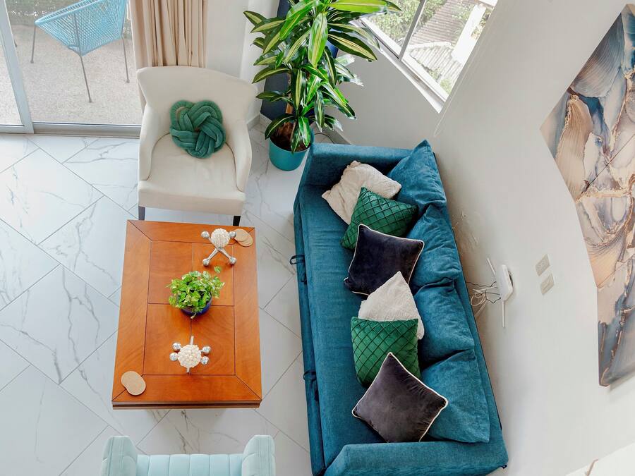 A modern living room with a sofa, a coffee table, a chair, and a potted plant.