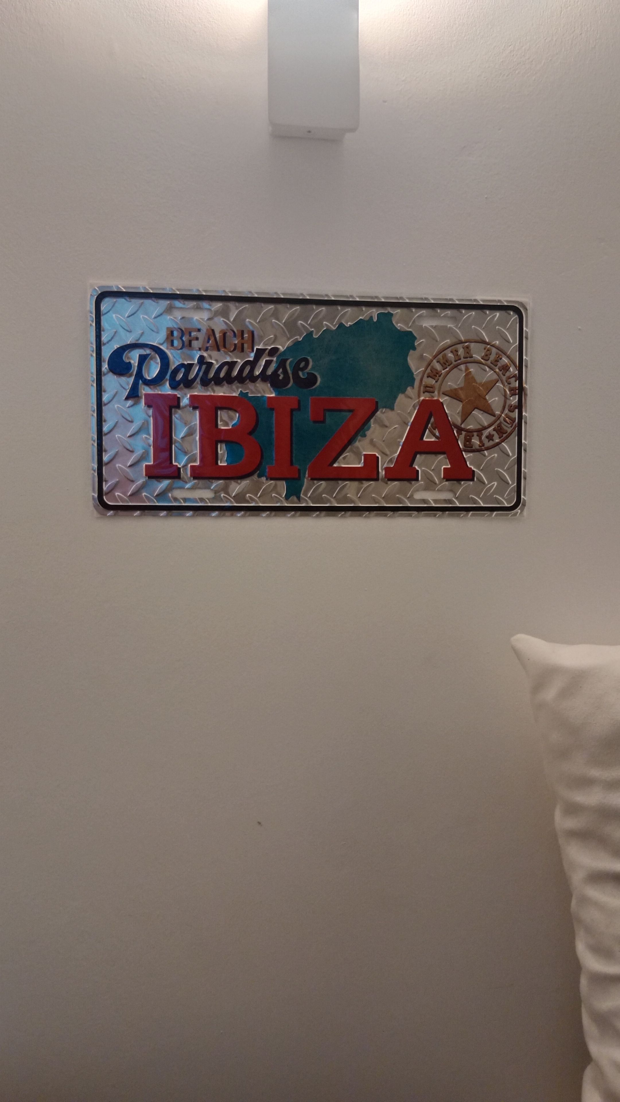 A wall-mounted sign with the text 'Beach Paradise Ibiza' and a star emblem.