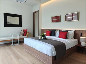 A modern hotel room with a large bed, a bedside table, a small white table, a bench, and a large mirror. - Aileen Layan Villa 2 Private Pool 4bedroom (Choeng Thale)