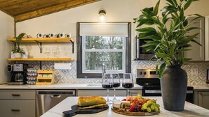 A modern kitchen with a marble countertop, a large potted plant, a fruit platter, and wine glasses. - Riverfront- 3 Hole Golf Course - Pool - Hot Tub - Sauna - 2 Game Rooms (Elkton)