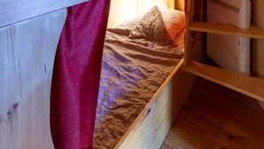 A bunk bed with a red curtain, wooden walls, and a ladder. - LA MAISON DU PAPE - BONNEVAL SUR ARC (BONNEVAL SUR ARC)