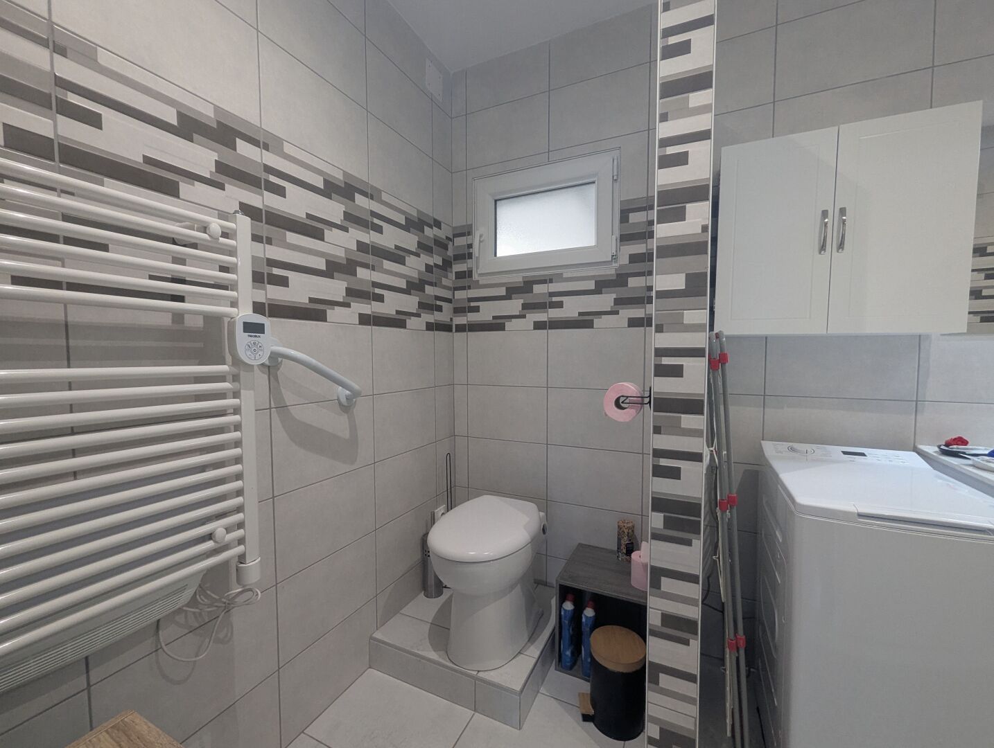 Une salle de bain comprenant des toilettes, un espace douche et un lavabo.