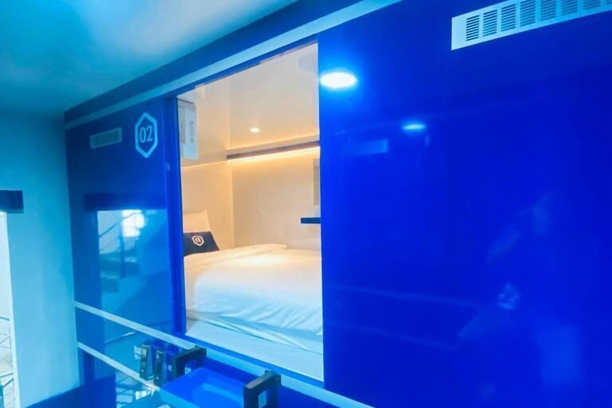 A hotel room with a bunk bed, a window with a view, and a small desk area.