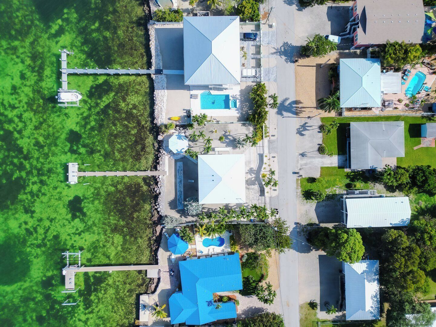 Eine Luftaufnahme eines Resorts mit mehreren Gebäuden, einem Steg und einem Swimmingpool.