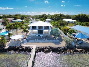 A two-story house with a pool, outdoor seating, and a dock leading to a beach. - Gulfside Gem   2bed/2bath Open Water Waterfront Escape (Marathon)