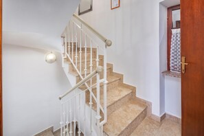 A staircase with white balusters and beige carpeted steps leading to a landing.