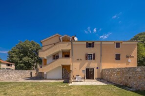 A multi-story building with a stone wall and a grassy courtyard. - Istrian Countryside House Iva, Rovinj-Krmed, Croatia (Krmed)