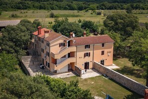 A multi-story building with a stone wall, a balcony, and a small garden area. - Istrian Countryside House Iva, Rovinj-Krmed, Croatia (Krmed)