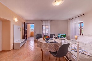 A hotel room with a dining area, a bed, a television, and a view of the outdoors. - Studio Iva 3, Rovinj-Krmed, Croatia (Krmed)