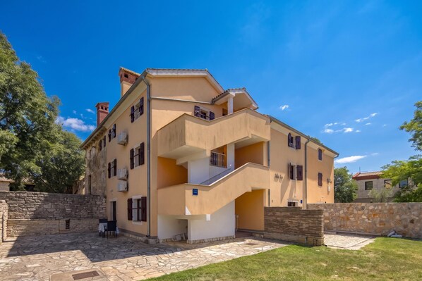 A multi-story residential building with a stone facade, a central staircase, and a small outdoor seating area. - Studio Iva 3, Rovinj-Krmed, Croatia (Krmed)