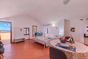 A bedroom with a bed, a bedside table with a lamp, a window with curtains, and a view of the outdoors. - Studio Iva 3, Rovinj-Krmed, Croatia (Krmed)