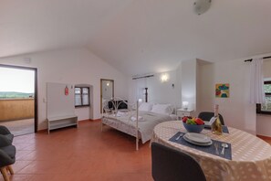 A bedroom with a bed, bedside table, and a dining table with a bowl of fruit and a bottle. - Apartment Iva 3, Krmed, Croatia (Krmed)