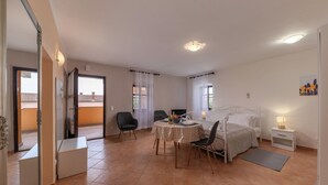 Une chambre à coucher comprenant un lit, une table de chevet, une lampe, une chaise et une petite table avec un bol.