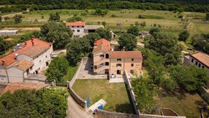 Un quartier résidentiel avec des maisons, un mur de pierre et un champ d’herbe.