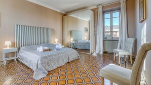 Une chambre d’hôtel avec un grand lit, une chaise, un miroir et une vue sur l’extérieur.