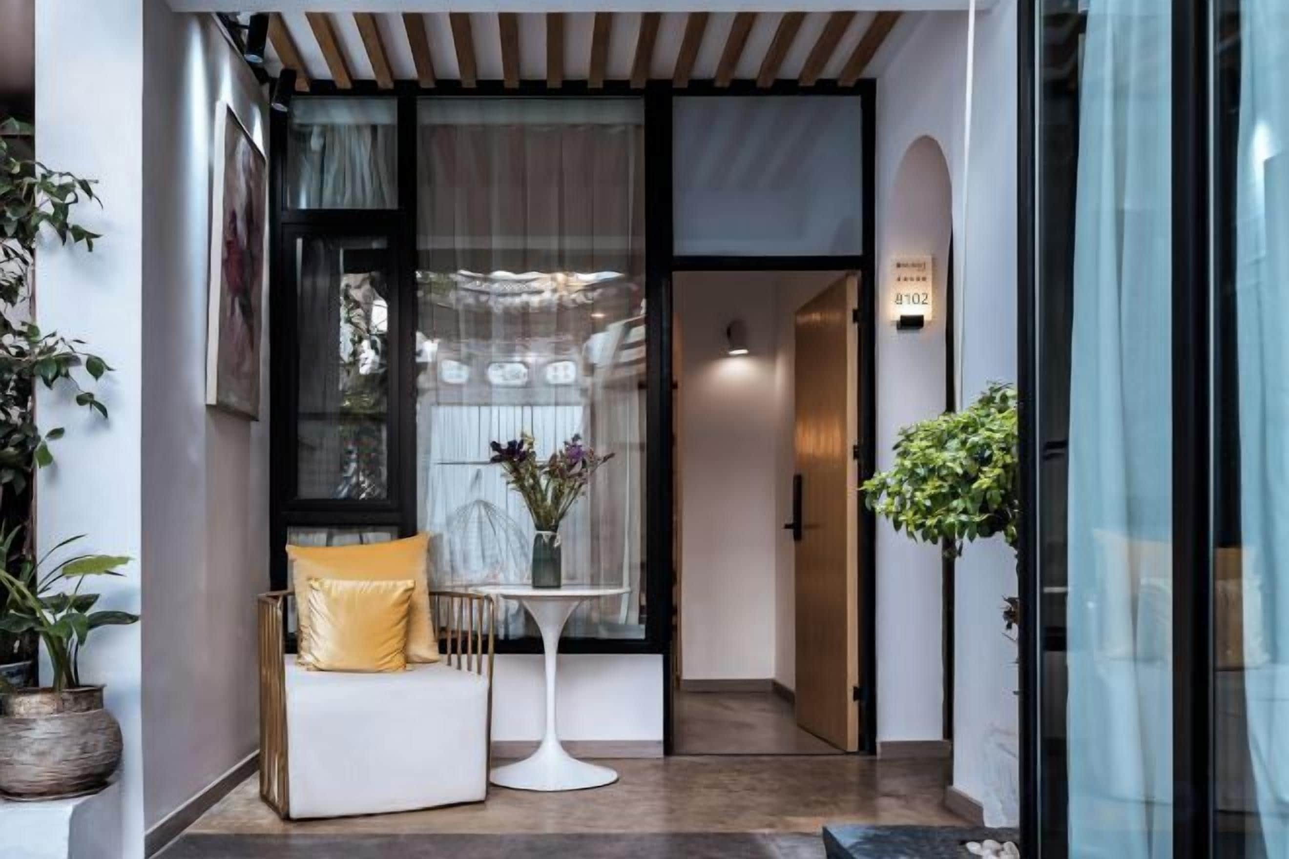 L’entrée d’un hôtel avec un espace salon, une petite table et une plante en pot.