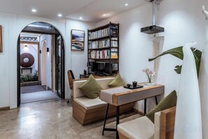 A modern living room with a sofa, a coffee table, a bookshelf, and a dining table. - Yelanyu Inn (Puxian Temple Store) (Dali)