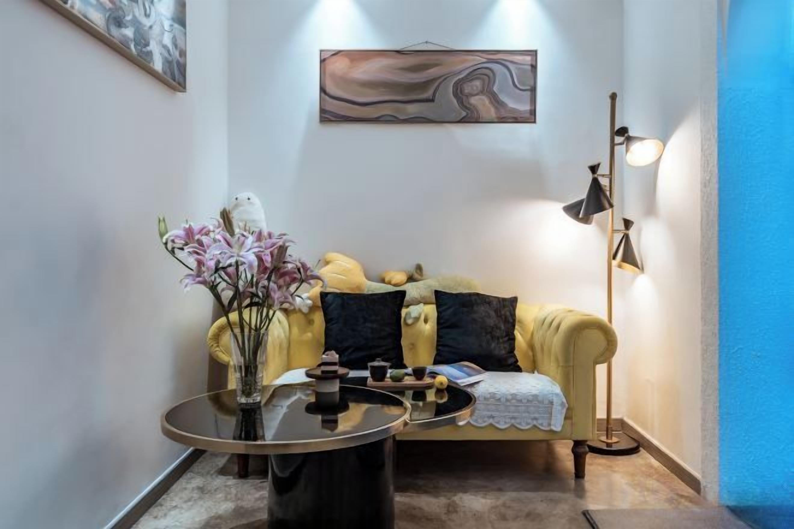 A living room with a sofa, a coffee table, and a floor lamp.
