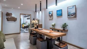 A modern dining area with a wooden table, grey upholstered chairs, and a bench.