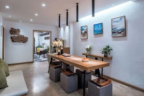 Un comedor moderno con una mesa de madera, sillas tapizadas en gris y un banco.