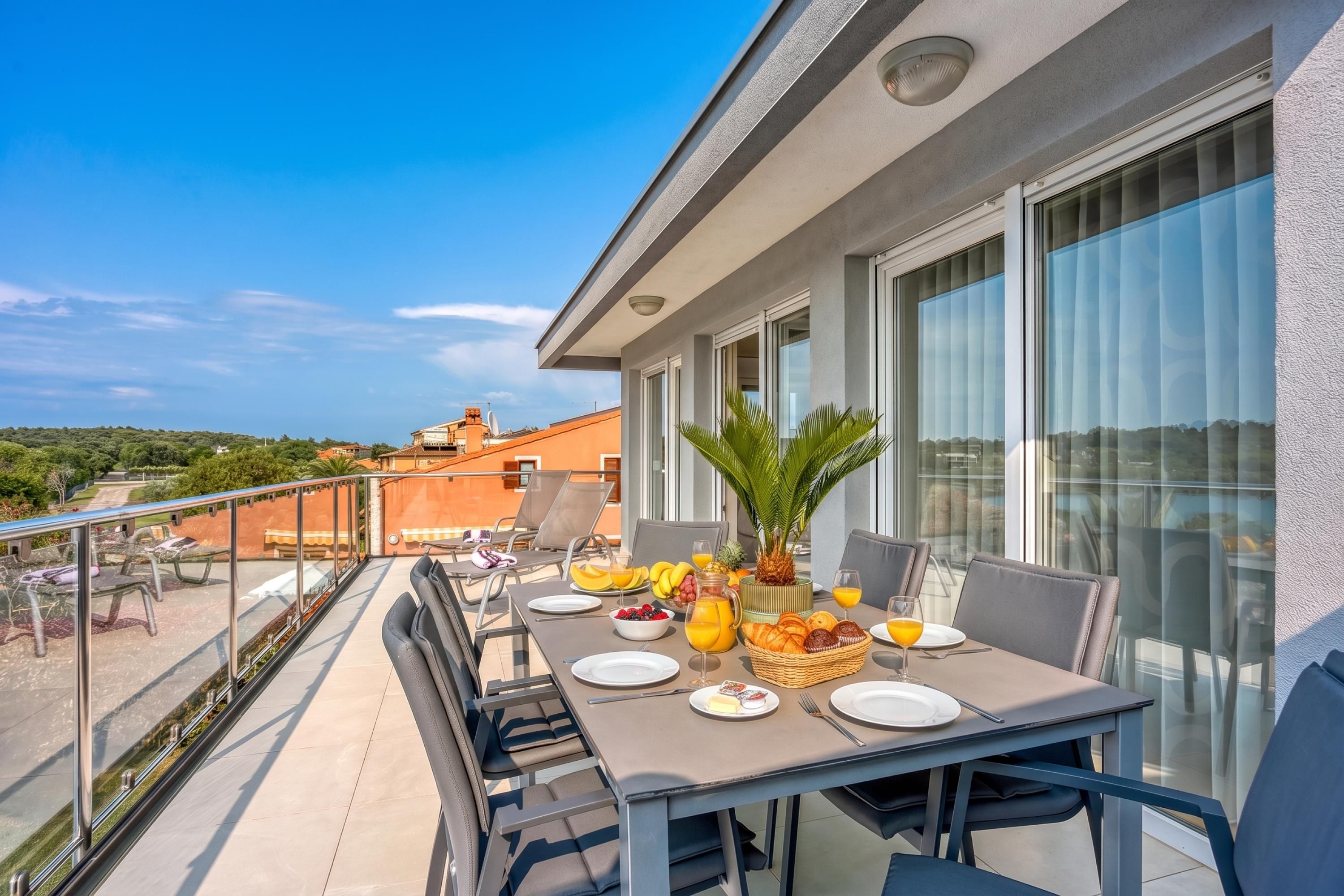 Un balcon avec une table préparée pour le petit-déjeuner, offrant une vue sur le paysage urbain.