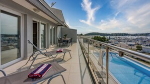 A balcony with a pool, glass doors, and a table with chairs. - Panoramic Sea view Apartment 3 with Pool, Pula, Croatia (Pula)