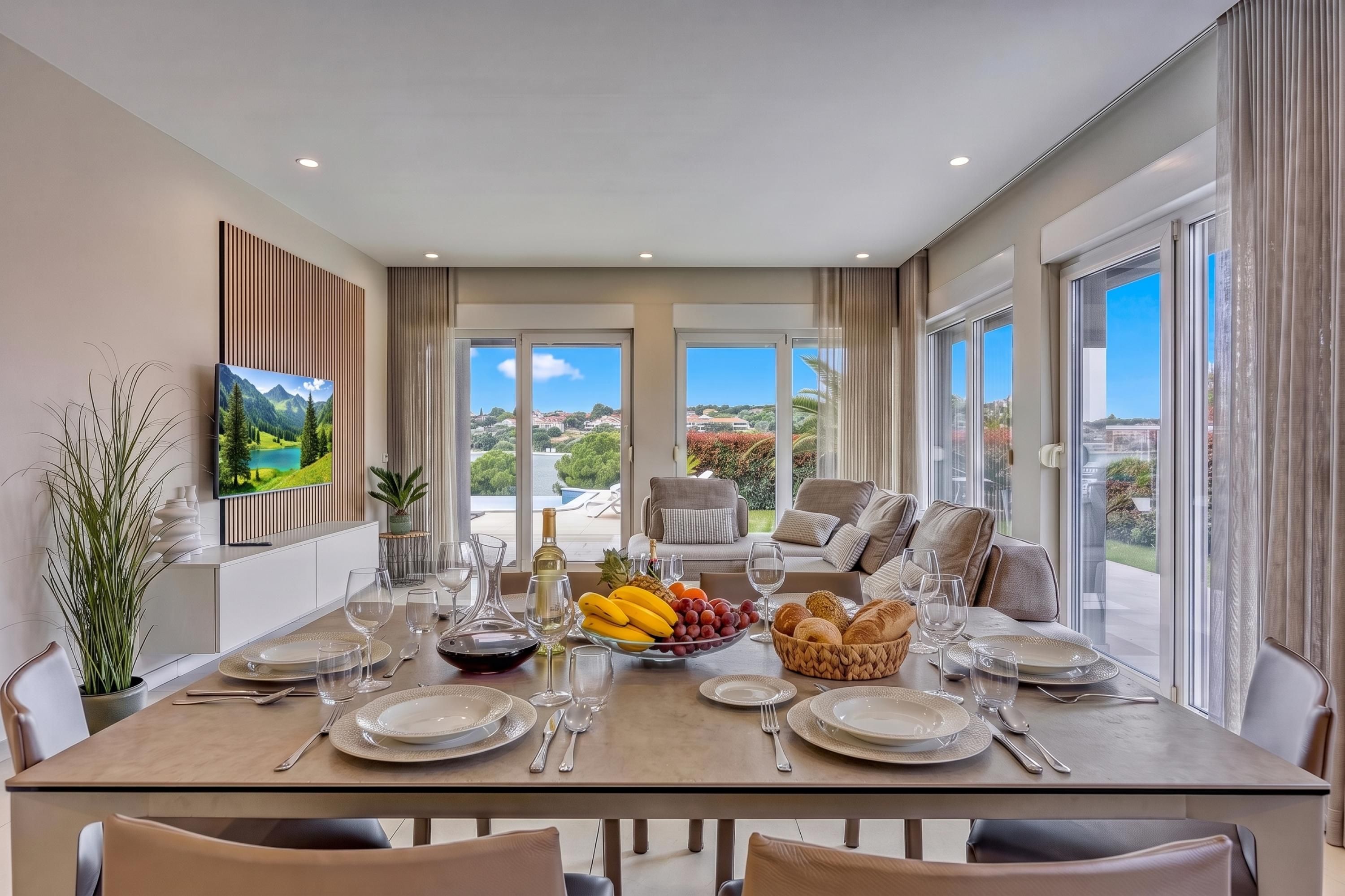 A dining area with a table set for six, large windows, and a view of the landscape.