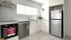 Une cuisine moderne avec des meubles blancs, un lave-vaisselle en acier inoxydable, un réfrigérateur et une fenêtre équipée de stores.