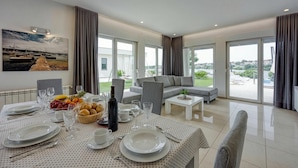 Een eetgedeelte met een tafel voor vier personen, een bank en uitzicht op de omgeving.