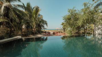 Een buitenzwembad, parasols bij het zwembad en ligstoelen
