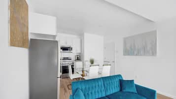 A modern apartment with a kitchen, dining area, and living room.