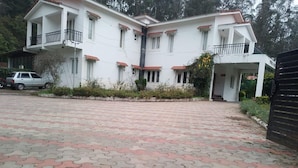 A two-story building with a tiled driveway. - KODAI FOGGY (Kodaikanal)