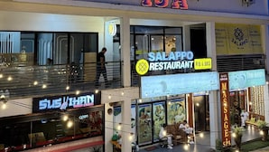 Un bâtiment sur lequel on peut lire l’inscription « ISA », avec un restaurant nommé « SALAPPO RESTAURANT RIB & BBQ » situé en dessous.