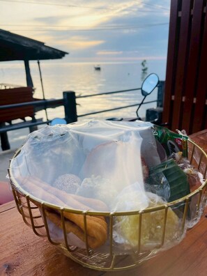 A bowl of food items on a table with a view of the sea in the background. - RabeangPhan Homestay Libong (Ko Libong)