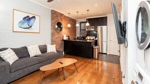 Una sala de estar moderna con un sofá gris, una mesa de centro de madera y un ventilador de techo.