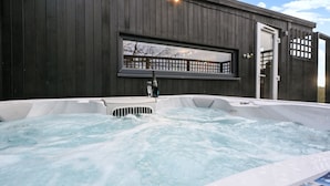 A hot tub with a wooden deck and a window overlooking a deck area. - Pilgrim -  a holiday let that sleeps 2 guests  in 1 bedroom (Tenterden)