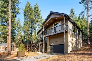 A modern two-story house with a balcony, a garage, and a staircase leading to the upper level.