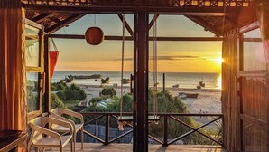 A wooden deck with chairs overlooking a beach at sunset. - Sampan Beach Resort Saintmartin (Saint Martin's Island)