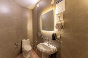 Een douche, handdoeken, zeep, toiletpapier