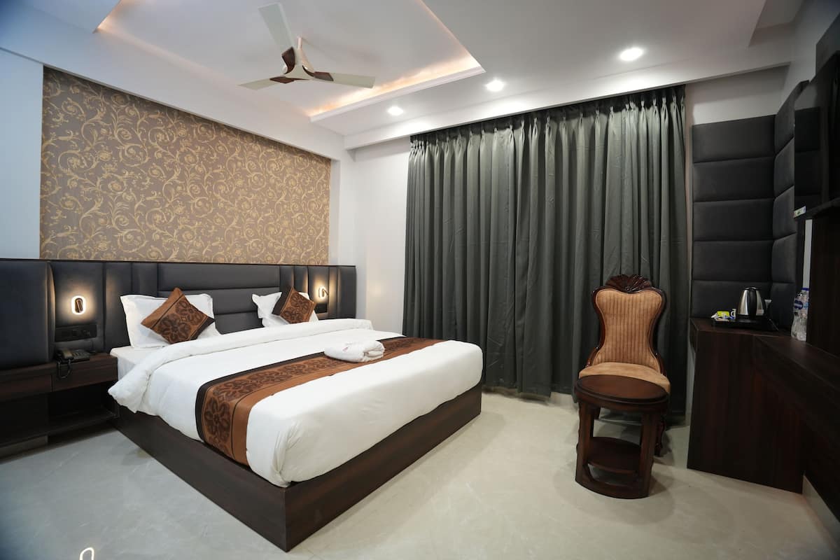 A modern hotel room with a large bed, a vanity, a chair, and a desk.